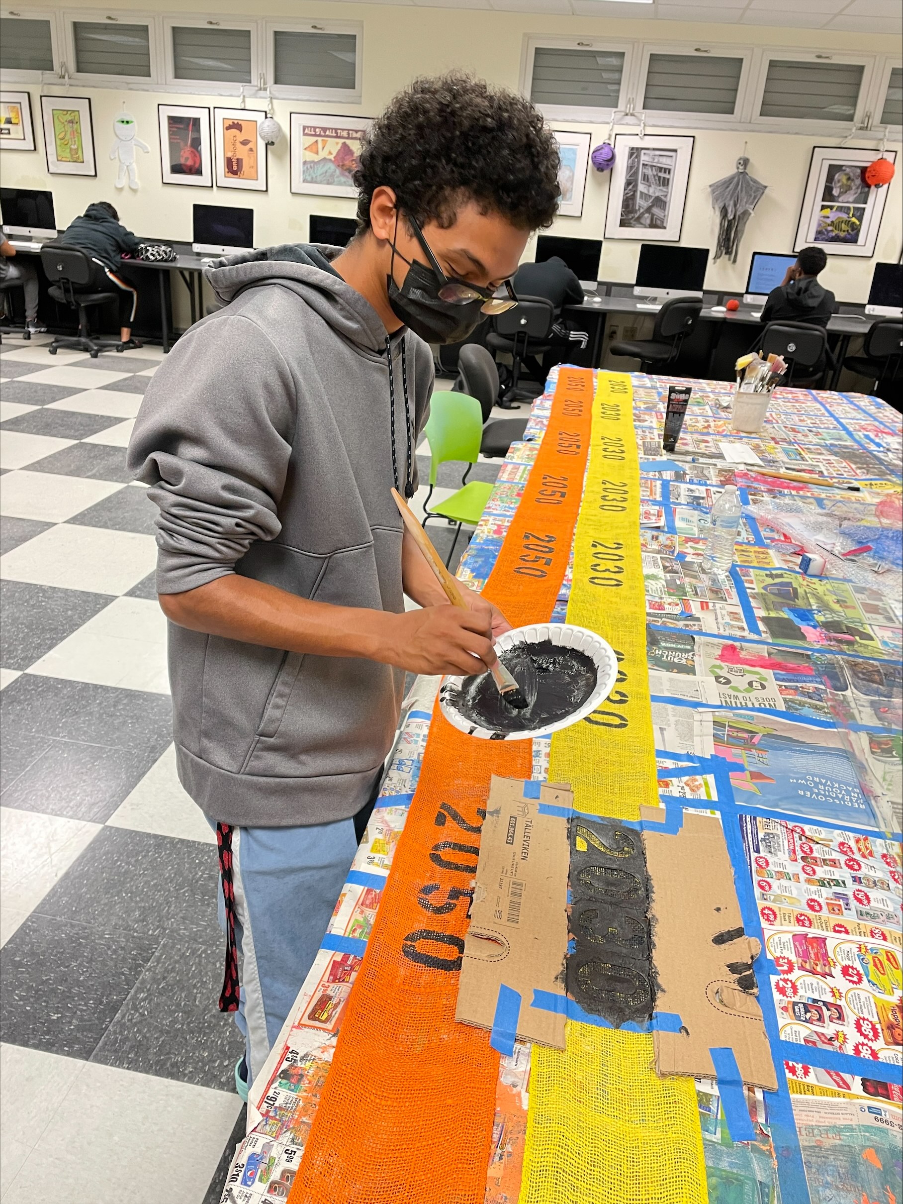 Student painting dates on fabric